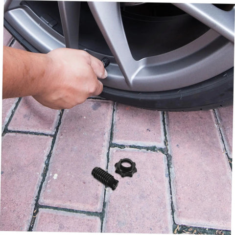 Heavy Duty Spare Tire Hold Down Bolt For Secure Tire Mounting And Easy Tightening Go To Car Spare Wheel Hardware For Reliable On Road Tire Replacement And Maintenance, man installing bolt on car wheel on brick pavement