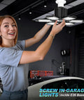 Woman installing LED Garage Lights 12 Pack Black Finish For Ultra Bright Even Coverage In Your Garage Shop Or Basement Energy Efficient Durable Fixtures Easy Install Wide Area Illumination For Any Workbench Environment