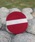 Silk Ito Sageo Wrapping Cord Sixteen Point Four Ft For Katana Wakizashi Samurai Swords on stones, coiled roll of red cord.
