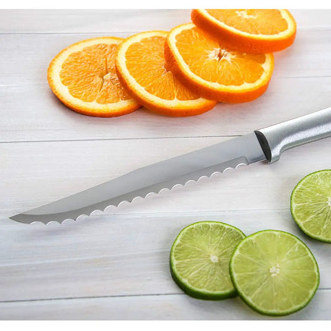 Smooth Serrated Slicer Knife With Knockout Double Sided Teeth That Crush Through Tough Produce Skins Like Hot Knife on countertop next to oranges and limes.