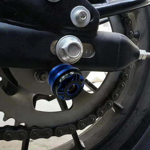Close-up of GSX 8R CNC Aluminum Swingarm Spool Slider Kit Orange Anodized Pro Grade Motorcycle Accessory mounted on swingarm