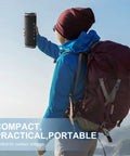 Hiker holding compact wireless Bluetooth speaker with 24W stereo sound, IPX7 waterproof, for outdoor adventures.