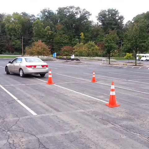 Car driving through parking lot with 6 Pack 28 Inch Traffic Cones With Reflective Collar For Parking Lots And Driving Training.