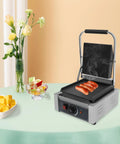 1800W Commercial Panini Press Grill Stainless Steel Electric Sandwich Maker cooking sausages on a table, showcasing adjustable temp control.