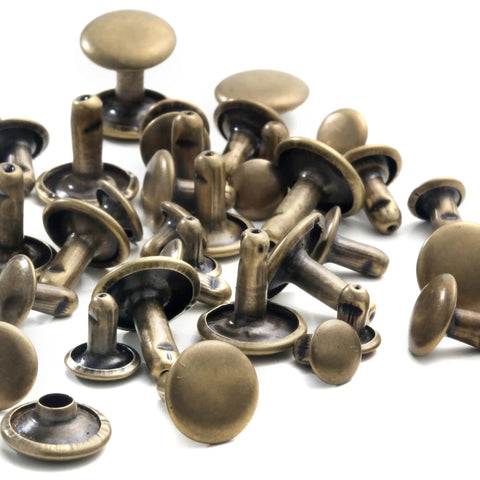 Heavy Hitter Copper Double Cap Leather Rivets Kit With Mixed Sizes And No Sweat Press Tool For Patching Denim Jackets Work Boots Canvas Totes Custom Gear Bronze, assorted bronze rivets laid out.