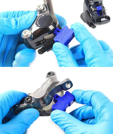 Hands using Six Piece Hydraulic Disc Brake Pad Spacer Set With Pro Grade Bleed Blocks to separate pads in bike calipers