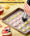 Stainless Steel Cookie Press Kit With 13 Discs And 8 Disc Set for DIY Baking in use decorating cookies on a baking tray.