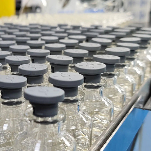 Slick Snap In Locking Silicone Hole Plugs For Round Rubber Panel Seal Covers And Waterproof Bulkhead Caps Hella Tough Flush Mount Design Pack Of Sixteen White Pieces displayed on glass bottles with gray caps.