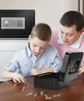 Father and son using a coin box, fireproof safe box with lock in background, home setting.