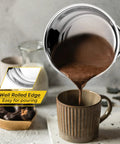 1 Quart Stainless Steel Saucepan With Glass Lid pouring chocolate into mug, showing rust free, easy pouring, durable small sauce pot