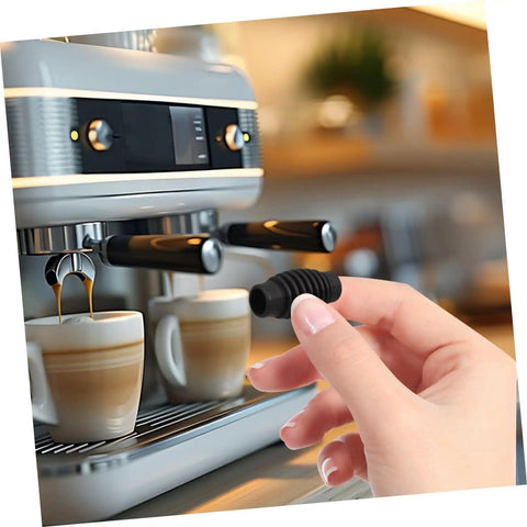 Hand holding a Heat Resistant Steam Wand Guard Rubber Sleeve For Espresso Machines Insulation Prevents Burns Stays Cool To The Touch Easy Slip On Durable Heat Shield Fits Most Home Barista And Commercial Espresso Makers near an espresso machine.