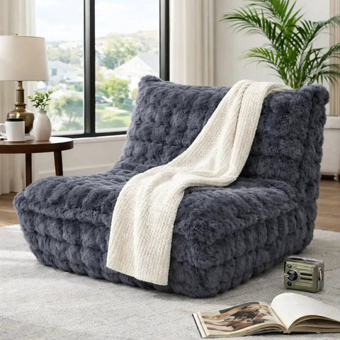 Faux Fur Memory Foam Bean Bag Chair With Filler, Ultra Soft Chill Fireside Lazy Sofa For Bedroom, Living Room, Office And Home, Dark Grey Cozy Seating with white throw in a room.