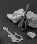Stainless Steel Multitool Keychain With Bottle Opener Screwdriver Imperial And Metric Ruler And Bike Spoke Key on rocks