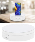 Electric Rotating Display Stand For Jewelry Watch Cosmetics And Toys 3 Speeds 360 Turntable With USB Charging Port ABS Material auto spin holder with smartphone on a wooden table