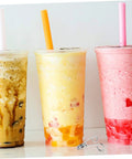 Three sealed bubble tea cups with colorful straws next to a 10 Piece Stainless Steel Spring Clips For Cup Sealing Machines Universal Replacement Accessories For Bubble Tea And Coffee Sealing No Fuss Setup Easy Installation And Secure Cup Mouth For Airtight Seal.