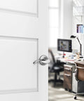 Satin Nickel Passage Lever Door Handle Set on white door, viewed from office side, for hallways and closets, non-locking, reversible.