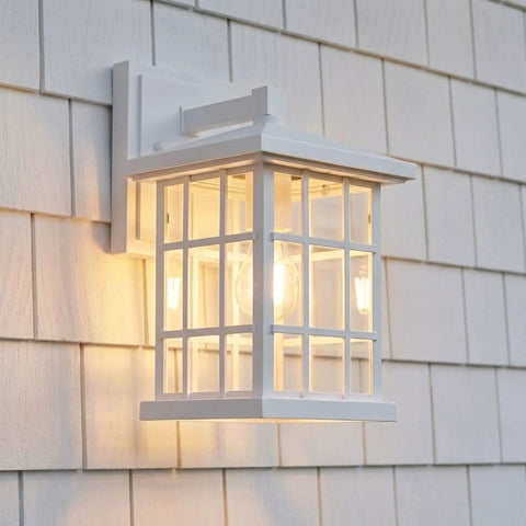 Stonington Outdoor Wall Lantern 13 Inch 1 Light Matte White Vintage Sconce With Old School Cottage Vibe And Clear Water Glass illuminated at dusk.