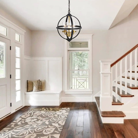 Rustic Farmhouse Chandelier 14-Inch Globe Pendant Light In Vintage Black And Gold hanging in a bright entryway with wooden stairs.