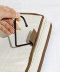 Hand holding a black hook for Total Closet Game Changer Hanging Purse Organizer For Wardrobe Dustproof Handbag Storage Rack.
