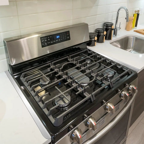 Stainless Steel Stove Gap Covers 2 Pack installed between stove and counter, heat resistant kitchen gap filler for appliances.