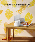 Cutting Machine 2 By HTVRONT 5 In 1 Vinyl Cutter with matless vinyl on wooden table, tropical leaf decor background.