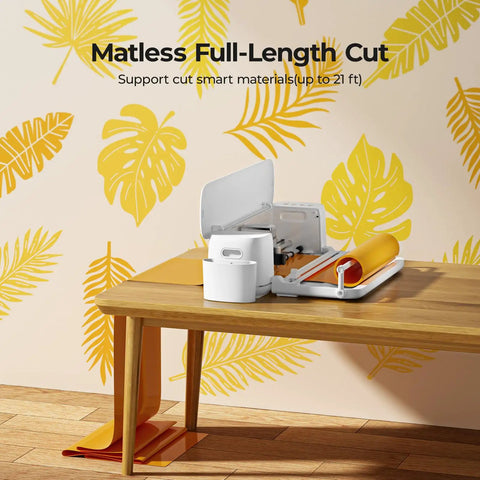 Cutting Machine 2 By HTVRONT 5 In 1 Vinyl Cutter with matless vinyl on wooden table, tropical leaf decor background.