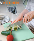 Person chopping vegetables in an RV kitchen using a cutting board and knife, featuring the Camping Cooking Utensils Set 16 Piece Camp Kitchen Kit With Organizer Bag Portable RV Camping Essentials Camper Must Haves For Cookouts And Open Fire Pit.