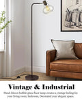 Farmhouse Bubble Glass Floor Lamp With Adjustable Tall Pole in living room next to sofa, Edison bulb glowing, oil rubbed bronze finish