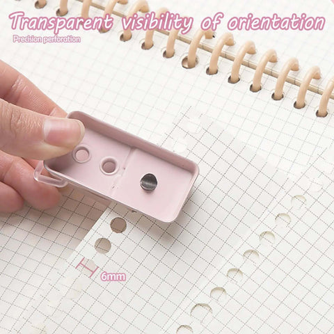 Hand using 2 Pack Mini Hole Punch 6mm Circle Holes Ultra Compact 10 Sheet Capacity Pocket Sized Puncher on notebook page