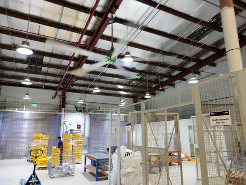 16 Ft Industrial HVLS Ceiling Fan With Brushless DC Motor Built In VFD And Wireless Remote Control operating in a large warehouse.