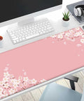 Pink Cherry Blossom Desk Pad 31.5 By 11.8 Inches With Non Slip Rubber Base Large Gaming Mouse Pad on a desk with computer and accessories.