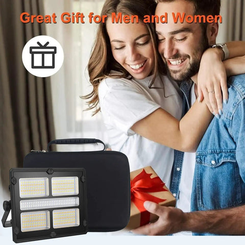 Super Bright Rechargeable Solar Work Light Packed With Huge Battery For All Your Camping Emergencies Storm Prep And Power Outages Portable Waterproof Lantern With Handy Hook And Stand Dimmable Settings Make It A Must Have, displayed with a gift-wrapped box and couple in background.