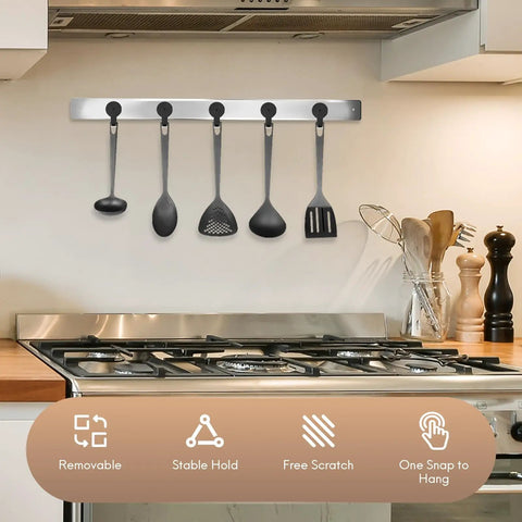 Wall-mounted kitchen utensil holder with five black utensils above a stovetop, showcasing stable and scratch-free features.