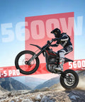 Rider on EM5 Pro 60V Electric Dirt Bike With Light And Display Off Road Motorcycle 5600W Power in rugged terrain, mid-jump.
