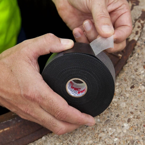 Hand holding Self Fusing Rubber Electrical Insulating Tape For Cable Splices And Terminations 2 In By 30 Ft Black Pro Grade Heavy Duty