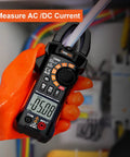 True RMS 6000 Counts Digital Clamp Meter Multimeter Auto Ranging Pro Grade Built In HD Screen measuring AC current in orange gloves