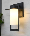 Top Tier Modern Outdoor Wall Sconce Featuring Waterproof Black Matte Aluminum Bracket And Cylindrical Glass Shade shown on a wall.