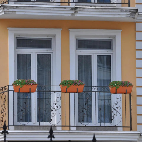 Kick It Up A Notch On Your Deck With These Sturdy Railing Planter Boxes Perfect For Balconies Patios And Windowsills Quick Setup Metal Brackets Included Deep Root Zone For Lush Greenery Classic Red Finish with flowers on a balcony railing.