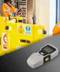 5-in-1 for stud Finder Sensor Wall Scanner LCD Display 5-in-1 on a table with workers and safety barriers in background.