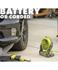 Ryobi 18V Cordless Hybrid Portable Fan Bundle With Seven And A Half Inch Blade in garage beside car, extension cord attached.