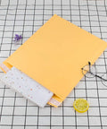 10x12.5 Inch Bubble Mailers 25 Pack Large Padded Envelopes Self Sealing Shipping Envelopes with paperwork on checkered surface