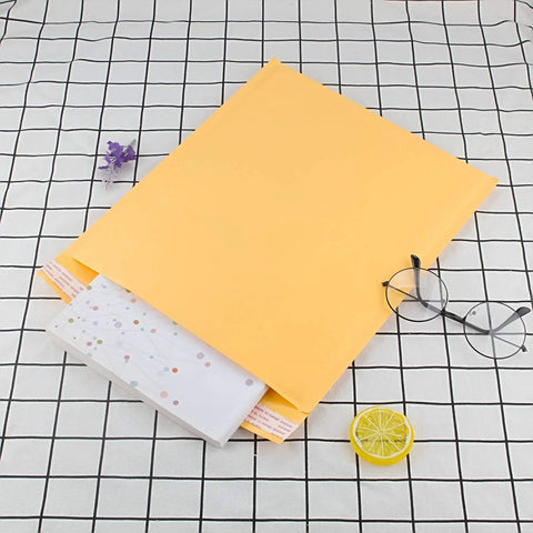 10x12.5 Inch Bubble Mailers 25 Pack Large Padded Envelopes Self Sealing Shipping Envelopes with paperwork on checkered surface