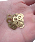 Hand holding EDC Knife Brass Washer Gasket Replacement Set For Bugout Axis Lock 535 Folding Knife 20 pack of brass washers