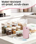 Slick Portable Bluetooth Label Maker With Wireless Tape, Compact Handheld Sticker Printer For Quick Adhesive Labels, Dope Pocket Sized Smart Thermal Device That Prints Crisp Labels No Cap on kitchen counter with labeled jars.