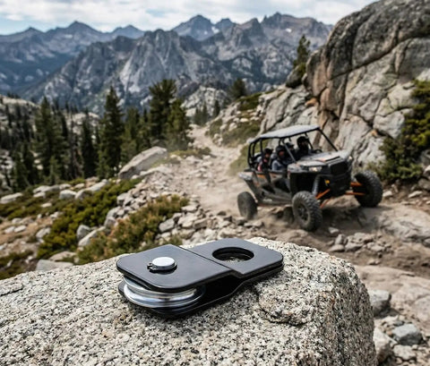 Beefy 4 Ton ATV And UTV Snatch Block For Winches, Doubles Your Winch Power, Heavy Duty 8,000 Pounds Capacity, Fits Polaris Honda Can Am ATVs And UTVs, Side By Side Accessories For Trail And Worksite. black steel snatch block on rock beside ATV on mountain trail