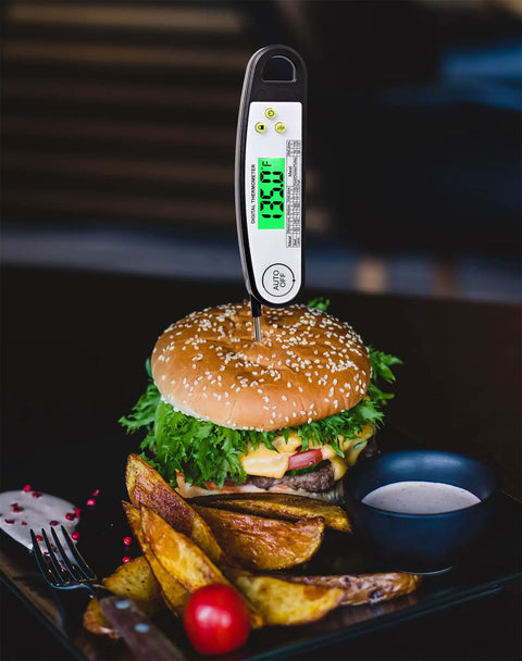 Digital Meat Thermometer For Grilling With Backlit Display, Instant Read In 2 To 4 Seconds inserted in burger on plate