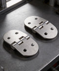Two Pack Heavy Duty Oval Hinges in 316 Stainless Steel for Outdoor Cabinets, Boat And RV Doors, Marine Grade, Corrosion Resistant, Smooth Quiet Operation, Built Tough For Harsh Environments. Two oval 316 stainless steel hinges on dark surface