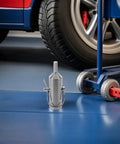 Universal Rv Dump Jack Drill Adapter Heavy Duty Premium Steel Drive Shaft Connector near vehicle tire on garage floor.