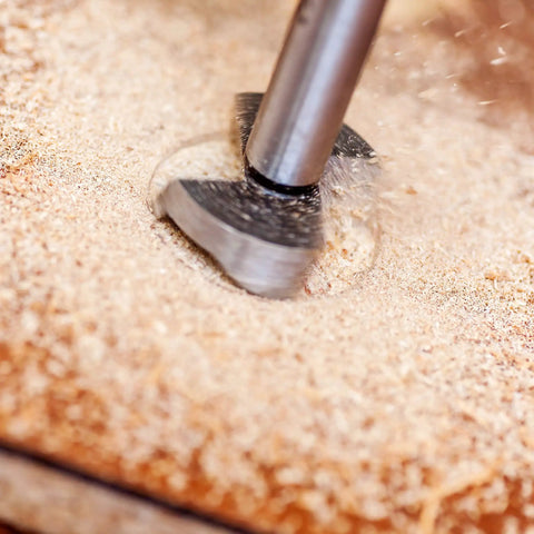 Workhorse Forstner Drill Bits Set Packing Two 24 And 25 Millimeter Cutters Featuring Razor Sharp Tungsten Carbide Heads in use on wood.