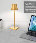 Cordless LED Desk Lamp On The Go with rechargeable 5000mAh battery next to a laptop, gold finish, USB-C cable connected